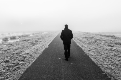 Man walking on an empty desolate raod